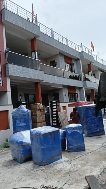 Blue wrapped goods outside house – Nation Packers And Movers