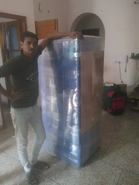 Packer with wrapped fridge – Nation Packers And Movers
